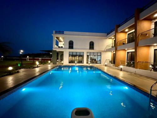 a swimming pool in front of a building at night at Aqualina in Bhogwe