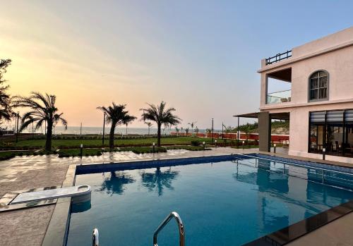 a large swimming pool in front of a building at Aqualina in Bhogwe