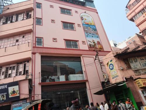 a tall pink building with a large window at KASHI DARSHAN in Varanasi
