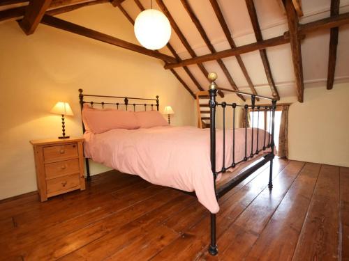 Schlafzimmer mit einem Bett und Holzboden in der Unterkunft 3 Bed in Ilfracombe GRAIC in West Down