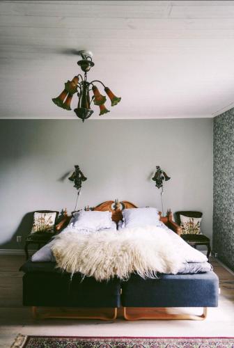 a bedroom with a bed with a white blanket at Snällfäll Country living - Åkerbo gård charmigt renoverad flygel in Kristinehamn