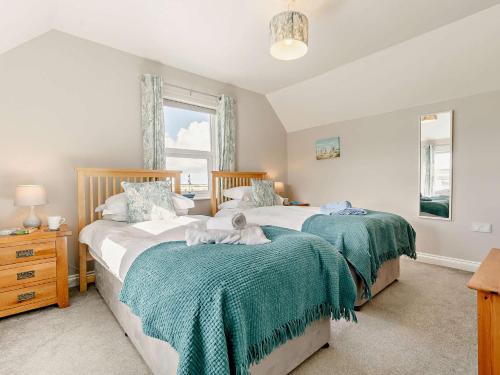 a bedroom with two beds and a window at 3 Bed in Newquay TREOC in Mawgan Porth