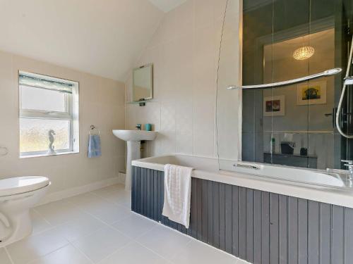 a bathroom with a tub and a toilet and a sink at 3 Bed in Newquay TREOC in Mawgan Porth
