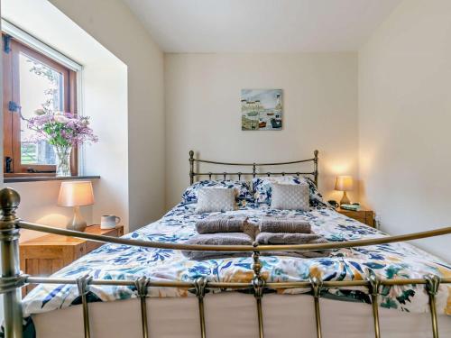 a bedroom with a bed with a blue and white comforter at 1 Bed in Helston BODER in Wendron