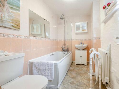 een badkamer met een bad, een wastafel en een toilet bij 2 Bed in Combe Martin 10007 in Combe Martin