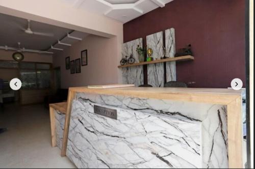 Hotel Shree Krishna Residency By BookingCare في Satna: كونتر من الرخام في غرفة مع جدار