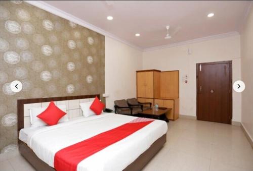 a bedroom with a large bed with red pillows at Hotel Shree Krishna Residency By BookingCare in Satna