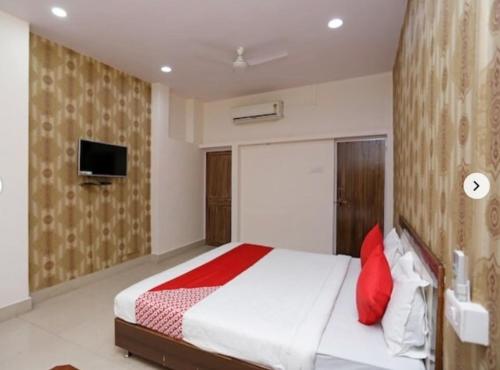 ein Schlafzimmer mit einem großen Bett mit roten Kissen in der Unterkunft Hotel Shree Krishna Residency By BookingCare in Satna