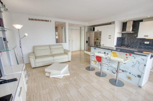 ein Wohnzimmer mit einem Sofa und einer Küche in der Unterkunft Le Clair Golfe-Juan - T2 terrasse vue mer Parking privé WIFI - LIMESTAY in Vallauris