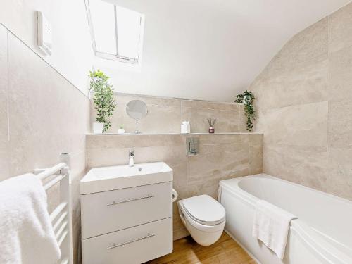 a bathroom with a toilet and a tub and a sink at 2 Bed in Little Longstone 44607 in Great Longstone