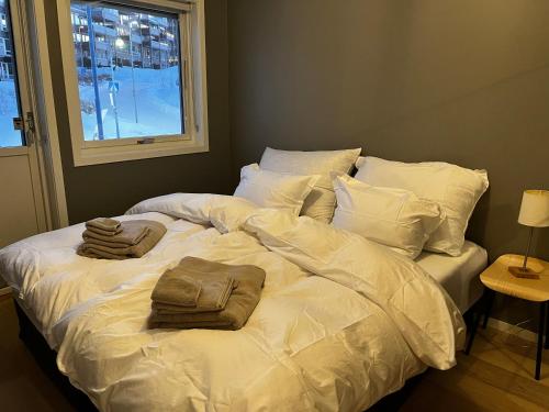 a white bed with two pillows on top of it at Nydelig rekkehus med en av byens beste utsikter! in Tromsø