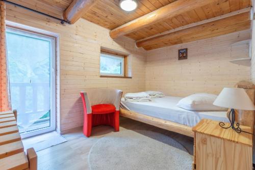 a bedroom with a bed and a chair and a window at Resort 7 Crai - Cabana Calinet in Zărneşti