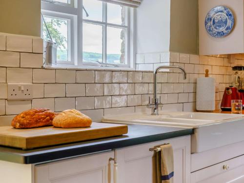 a kitchen counter with a cutting board with bread on it at 3 Bed in Crickhowell 48309 
