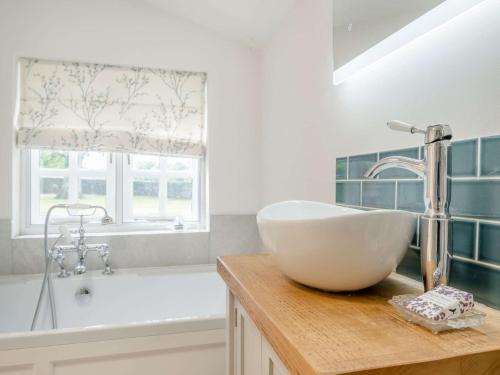 a bathroom with a sink and a bath tub at 1 Bed in Brecon 88748 in Aber-Brân