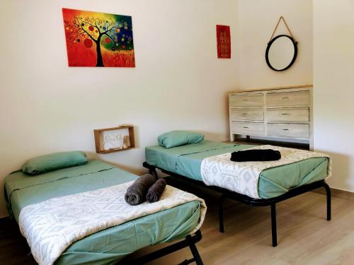 sypialnia z dwoma łóżkami i obrazem na ścianie w obiekcie La casa del Río Grande w Kordobie