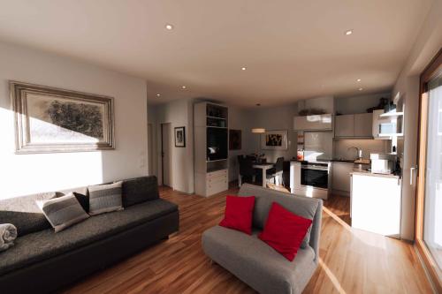 a living room with a gray couch and red pillows at Nina´s Home in Gablitz