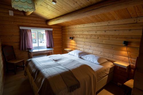 a bedroom with a bed in a wooden cabin at Åndalsnes Hytteutleie in Åndalsnes