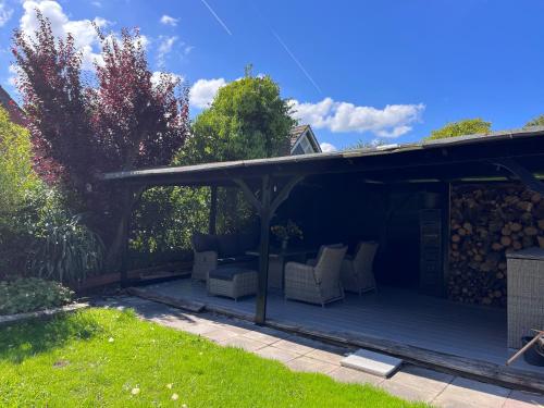 un pergolato con sedie bianche su un patio di Cosy Vacation home with large fenced garden a Bruinisse