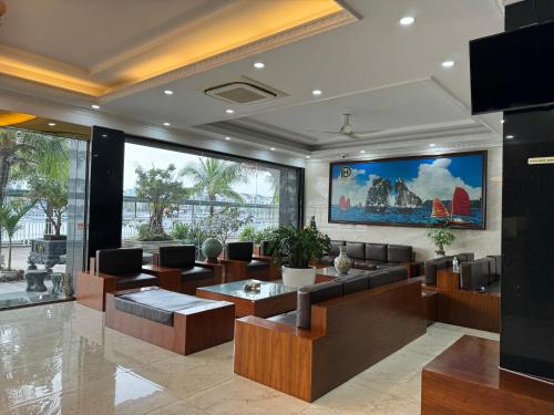 Hạ Long Land Hotel في ها لونغ: غرفة معيشة مع كنب وطاولات في مبنى