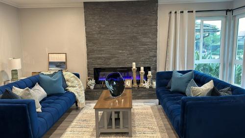 a living room with blue couches and a table at Serenity Health Residential Care Home in Mission Viejo