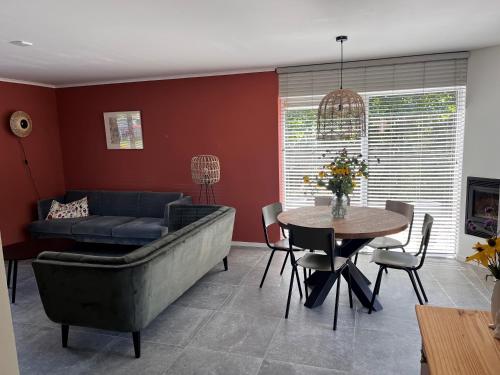 a living room with a couch and a table at Cosy Vacation home with large fenced garden in Bruinisse
