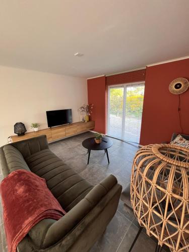 een woonkamer met een bank en een tafel bij Cosy Vacation home with large fenced garden in Bruinisse
