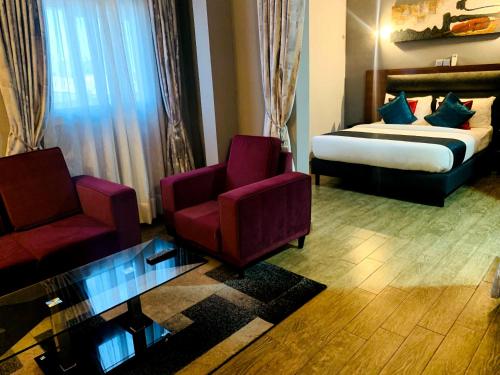 a hotel room with a bed and a couch and chairs at LA ROCHELLE HOTEL in Yaoundé
