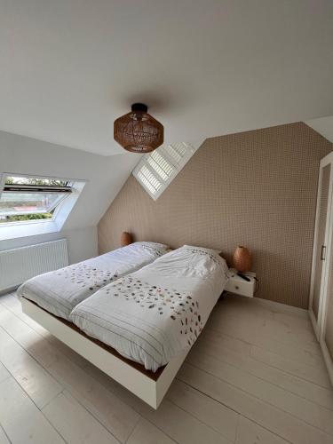 a bedroom with a bed and a ceiling with a window at Cosy Vacation home with large fenced garden in Bruinisse