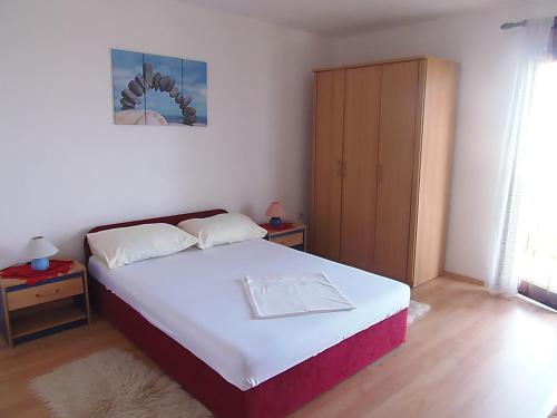 a small bedroom with a bed and a cabinet at Sunflower Apartment in Opatija