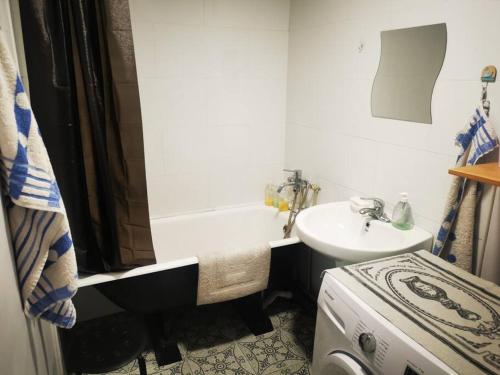 a small bathroom with a sink and a bath tub at Chic 2-Bedroom Apartment in 13th district in Ulaanbaatar