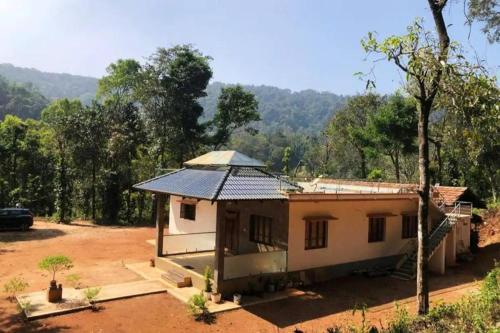 a small house in the middle of a field at Adis home- with waterfalls in Kalasa