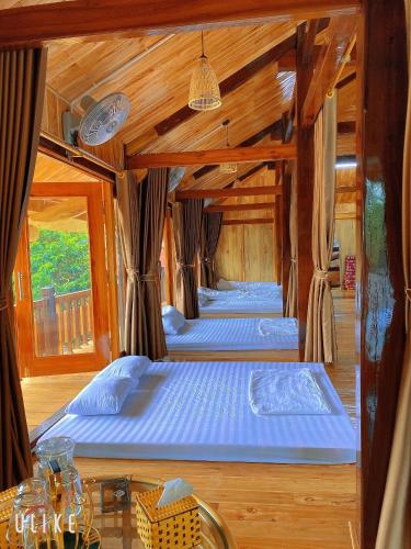 two beds in a room with wooden walls at Nam Nam Homestay in Bản Cong Na