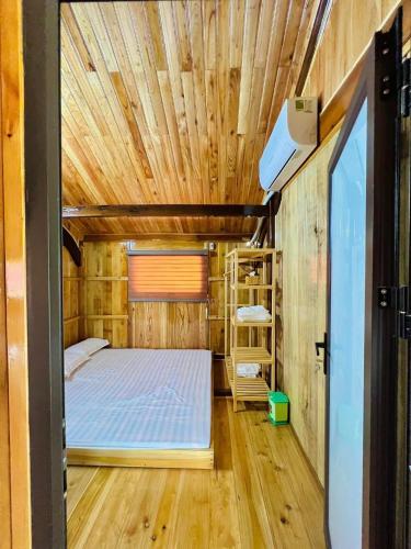 a small bedroom with a bed and a wooden ceiling at Nam Nam Homestay in Bản Cong Na