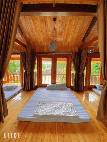 Nam Nam Homestay في Bản Cong Na: غرفة نوم مع مرتبة كبيرة على أرضية خشبية