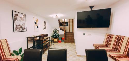 a living room with two chairs and a flat screen tv at Casa Sena in Moieciu de Sus