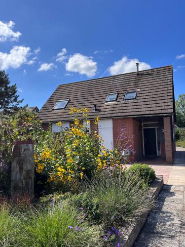 a house with flowers in the front yard at Cosy Vacation home with large fenced garden in Bruinisse