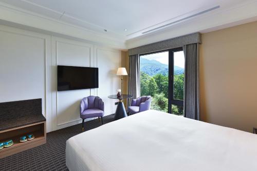 a hotel room with a bed and a large window at Fullon Poshtel - Shuili in Shuili