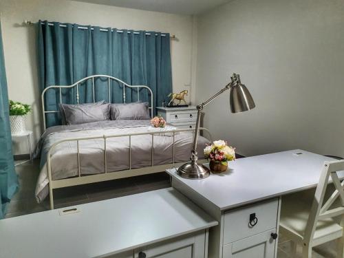 a bedroom with a bed and a desk with a lamp at 3 BR Cozy Home Skytrain View BKK in Bangkok
