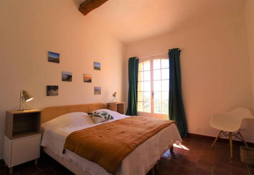 a bedroom with a large bed and a window at Villa Tara 6 chambres piscine privée vue panoramique sur les collines de Grimaud in Grimaud