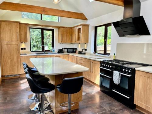 a kitchen with wooden cabinets and a black stove top oven at Paultons Golf Lodge in Ower