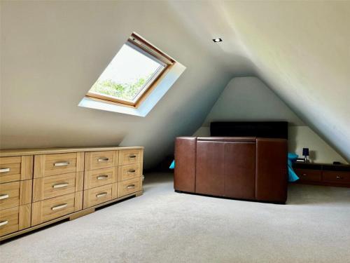 a attic room with a bed and a window at Paultons Golf Lodge in Ower