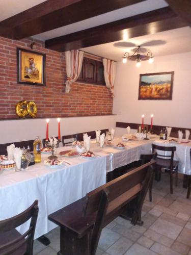 a dining room with long tables with candles on them at Къща за гости "Тони" in Dobrinishte