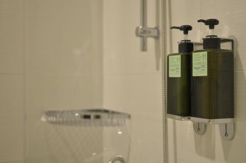 a green fire hydrant on a wall next to a mirror at Stay Hotel - Taichung Yizhong in Taichung