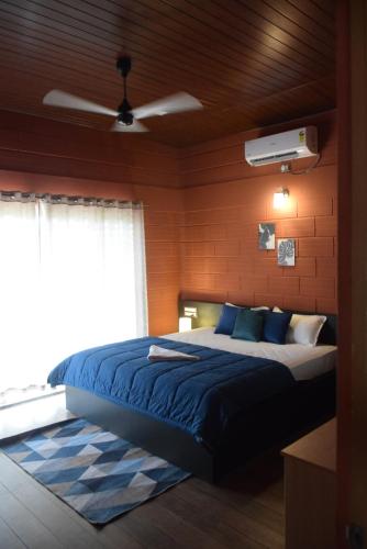 1 dormitorio con 1 cama grande con almohadas azules en Golden Triangle, en Hampāpura