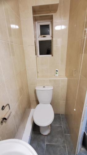 een kleine badkamer met een toilet en een raam bij Cosy And Relaxing in Chatham