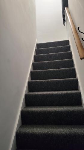 una escalera en un edificio con alfombra negra en Cosy And Relaxing, en Chatham