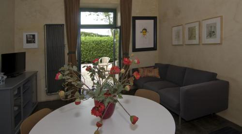 a living room with a couch and a table with flowers at b&b Het Wolfshuis in Bemelen