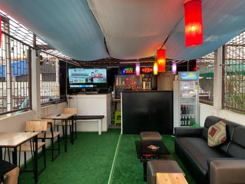 a restaurant with green flooring and a couch and tables at wonderful hostel khaosan in Bangkok