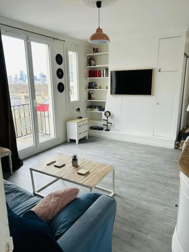 un salon avec un canapé et une table basse dans l'établissement Appartement charmant parisien, à Paris