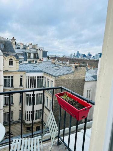 un planteur sur un balcon avec vue sur la ville dans l'établissement Appartement charmant parisien, à Paris